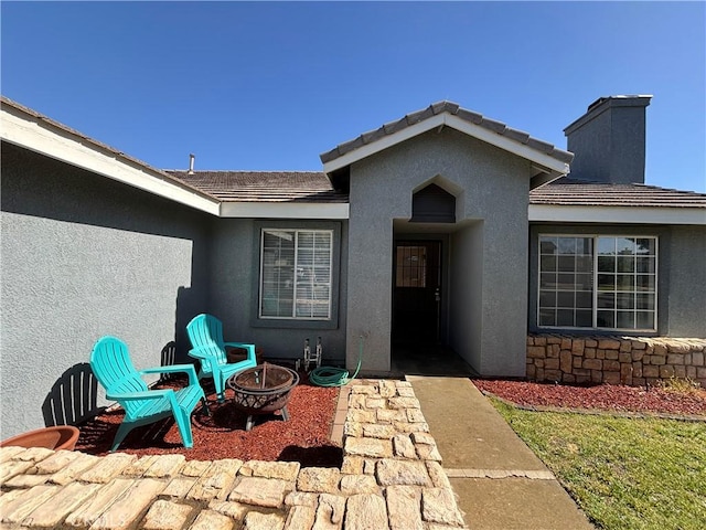 5314 Carlo Ct, Palmdale, CA 93552 - view of exterior entry featuring stucco siding, a tiled roof, and a chimney