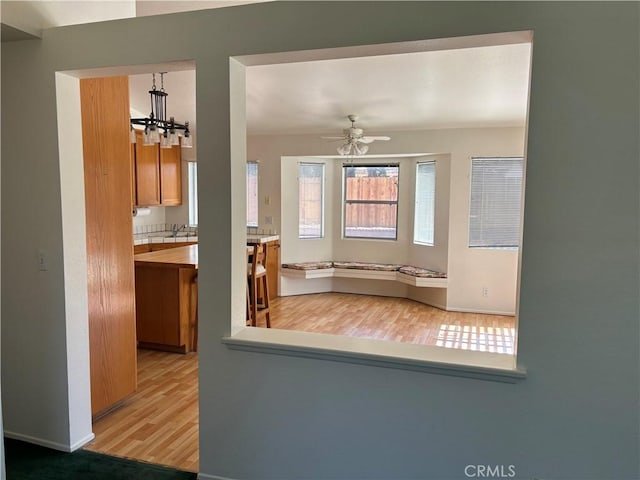 5314 Carlo Ct, Palmdale, CA 93552 - kitchen with light wood-style floors, ceiling fan, brown cabinetry, a chandelier, and light countertops