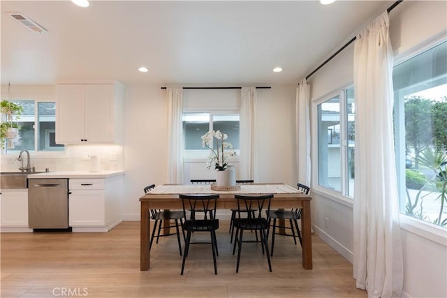 dining room with light wood-type flooring, recessed lighting, and baseboards