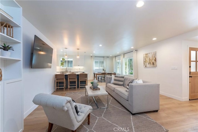 living room with light wood-style flooring, recessed lighting, and baseboards