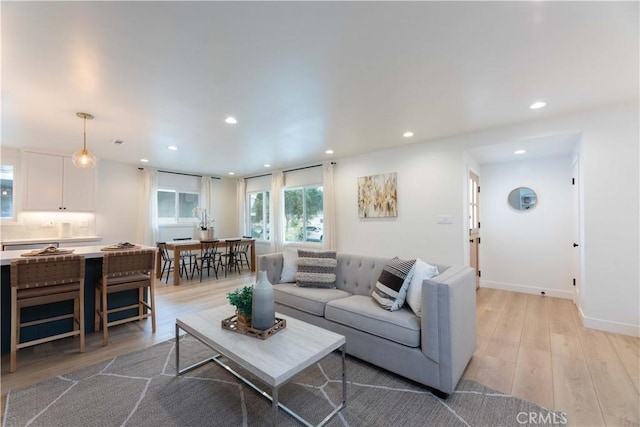 living room featuring recessed lighting, light wood-style flooring, and baseboards