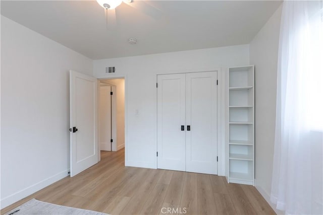 unfurnished bedroom with light wood finished floors, baseboards, a closet, and a ceiling fan