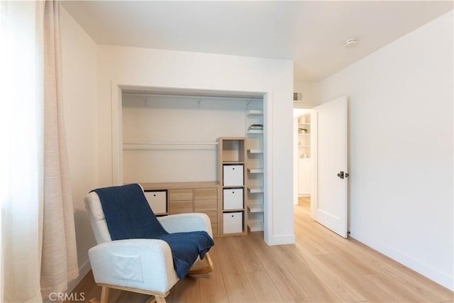 living area featuring light wood finished floors and baseboards