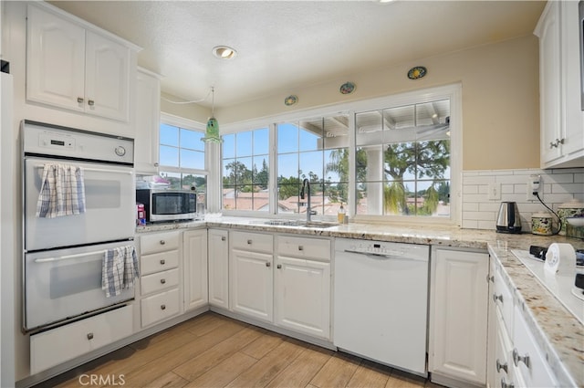 11806 Thunderbird Ave, Porter Ranch, CA 91326 - kitchen with white appliances, a sink, white cabinets, tasteful backsplash, and light wood finished floors