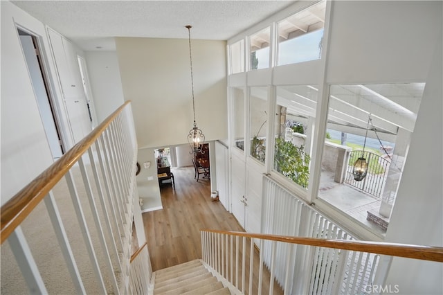 11806 Thunderbird Ave, Porter Ranch, CA 91326 - staircase featuring a chandelier, a towering ceiling, wood finished floors, plenty of natural light, and a textured ceiling