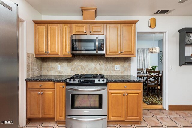 5627 Huddart Ave, Arcadia, CA 91006 - kitchen with stainless steel appliances, backsplash, dark stone counters, brown cabinetry, and light tile patterned floors