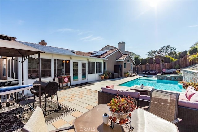 view of pool featuring french doors, outdoor lounge area, a patio, a fenced backyard, and outdoor dining space