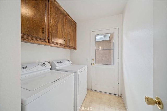 laundry room with washing machine and dryer, cabinet space, and light floors