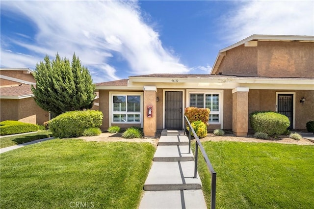 view of front of property with a front yard and stucco siding