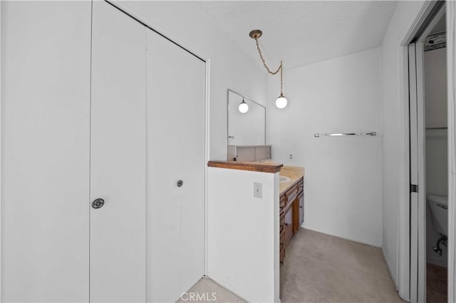 bathroom featuring vanity, toilet, a textured ceiling, and baseboards
