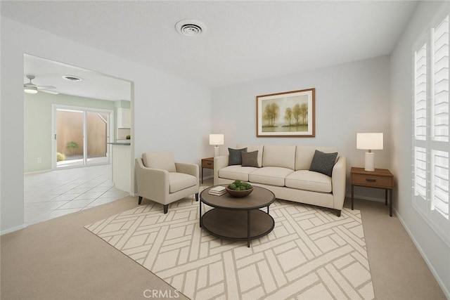 living room with light colored carpet, a ceiling fan, and baseboards