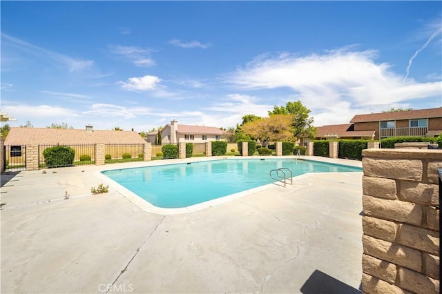 view of swimming pool featuring fence and a patio area