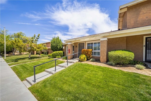 view of front of house featuring a front lawn and stucco siding