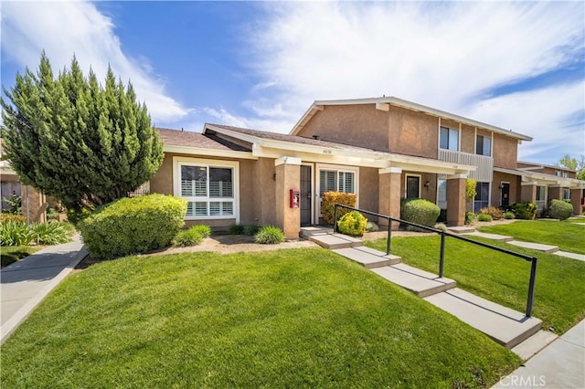 traditional home with stucco siding and a front yard