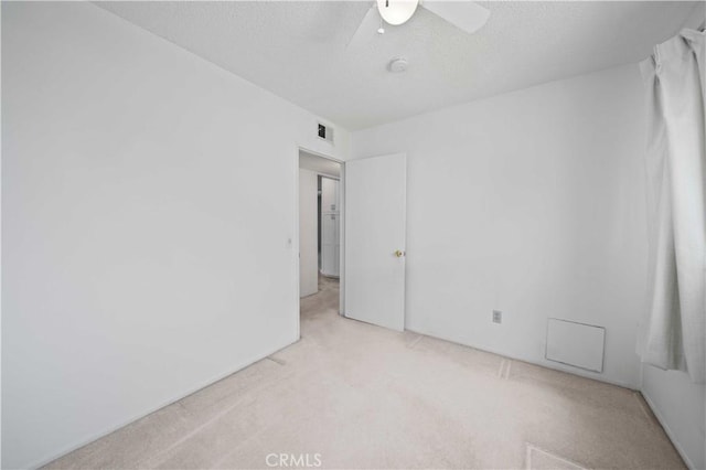 unfurnished room with carpet flooring, ceiling fan, a textured ceiling, and a smoke detector
