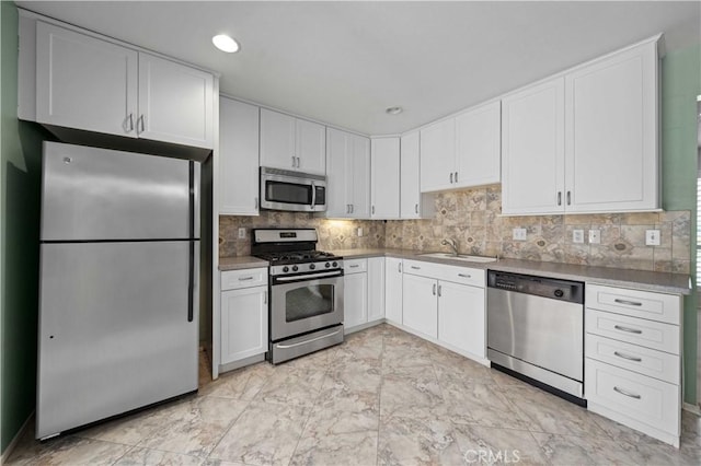 kitchen with stainless steel appliances, a sink, white cabinets, backsplash, and recessed lighting