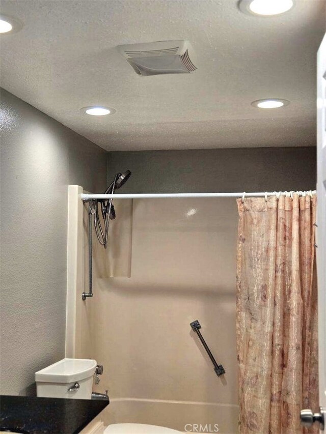 bathroom featuring toilet, recessed lighting, and shower / tub combo