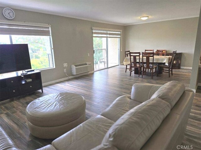 living area with a wall mounted AC, baseboards, wood finished floors, and crown molding