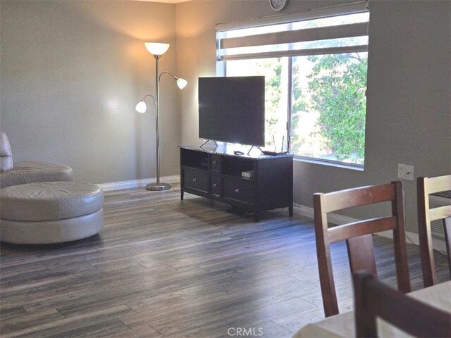 living area featuring baseboards and wood finished floors