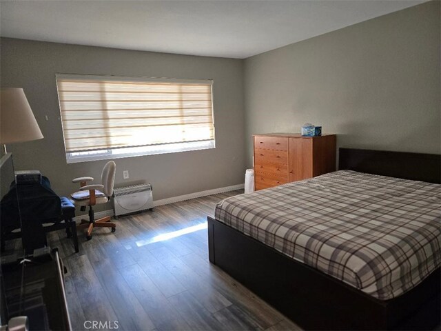 bedroom featuring wood finished floors and baseboards