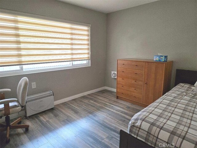 bedroom with wood finished floors and baseboards