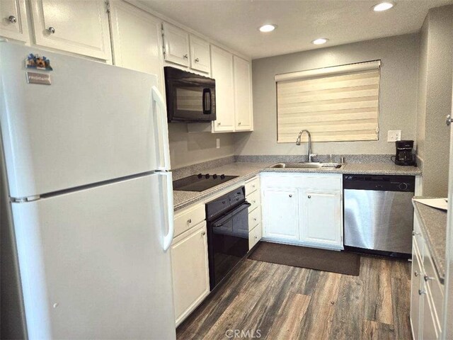 kitchen with black appliances, a sink, dark wood-style floors, white cabinetry, and recessed lighting