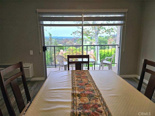 dining space with baseboards and wood finished floors