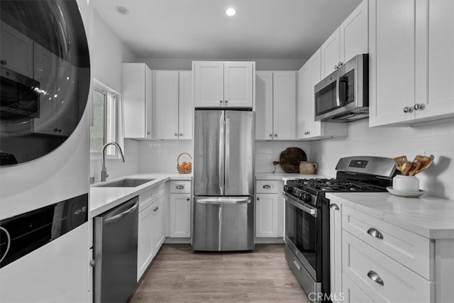 354 E 111th St, Los Angeles, CA 90061 - kitchen with stainless steel appliances, a sink, light countertops, white cabinetry, and recessed lighting