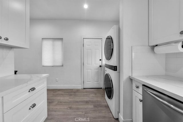 354 E 111th St, Los Angeles, CA 90061 - washroom featuring stacked washing machine and dryer, wood finished floors, baseboards, and recessed lighting