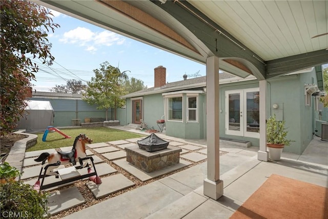 6911 E 10th St, Long Beach, CA 90815 - view of patio / terrace with french doors, an outdoor fire pit, a storage shed, fence, and central AC