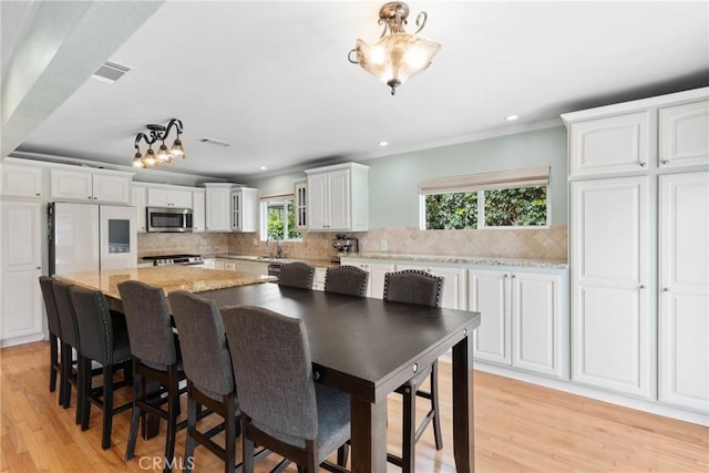 6911 E 10th St, Long Beach, CA 90815 - dining space with light wood-type flooring, recessed lighting, and ornamental molding
