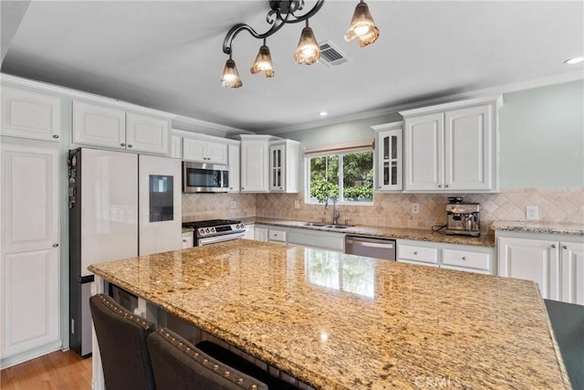 6911 E 10th St, Long Beach, CA 90815 - kitchen featuring stainless steel appliances, a sink, crown molding, a chandelier, and white cabinets