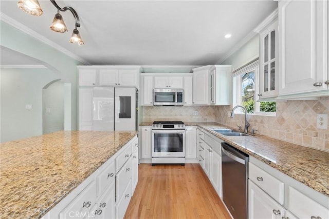 6911 E 10th St, Long Beach, CA 90815 - kitchen with stainless steel appliances, a sink, ornamental molding, white cabinetry, and light wood-type flooring