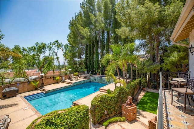 view of swimming pool with a patio, a fenced backyard, and grilling area