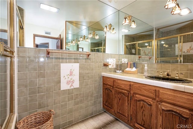 full bath with tile walls, a tile shower, tile patterned floors, vanity, and backsplash