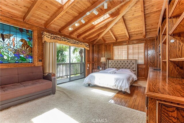 carpeted bedroom featuring access to outside, wood walls, wood ceiling, track lighting, and hardwood / wood-style flooring