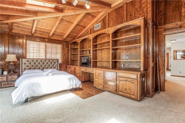 bedroom with wood ceiling, light colored carpet, and wooden walls