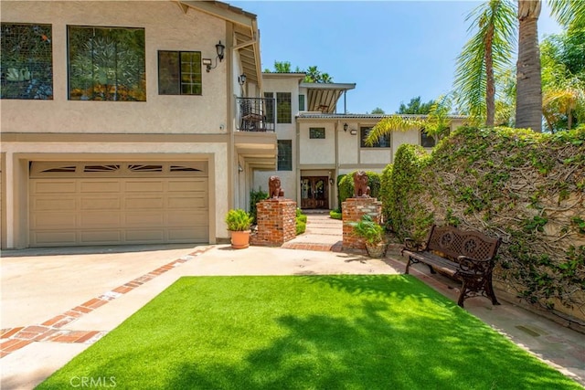 mediterranean / spanish home featuring a balcony, driveway, stucco siding, a garage, and a front yard