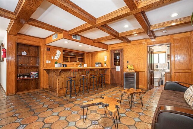 indoor wet bar featuring wine cooler, coffered ceiling, beamed ceiling, wood walls, and recessed lighting