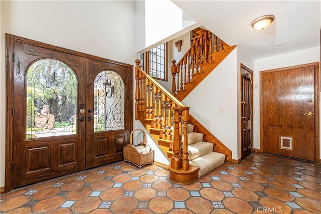 foyer featuring french doors, stairway, and baseboards