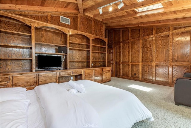 carpeted bedroom featuring wood ceiling, wooden walls, rail lighting, and beamed ceiling
