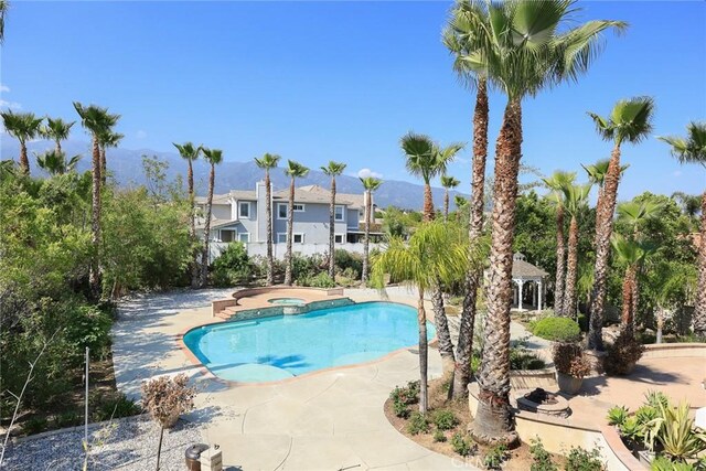 view of swimming pool featuring a mountain view and a pool with connected hot tub