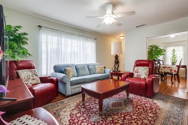 living area with a ceiling fan and wood finished floors