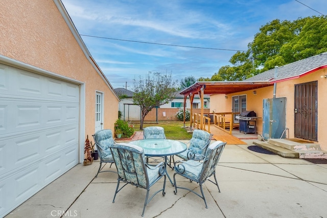 view of patio / terrace with a grill, outdoor dining area, an outdoor structure, a deck, and fence