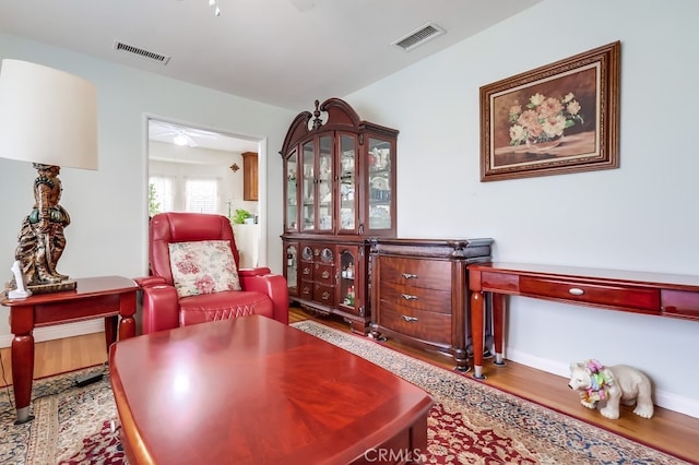 sitting room with ceiling fan, wood finished floors, and baseboards