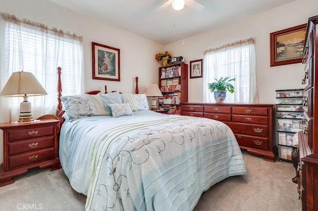bedroom with light carpet and a ceiling fan