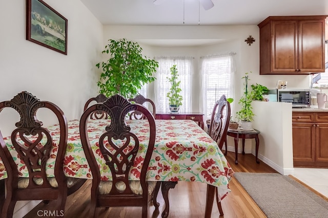dining room featuring light wood finished floors and ceiling fan