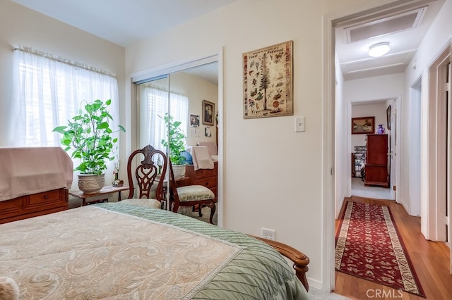 bedroom with light wood-style flooring, a closet, and baseboards