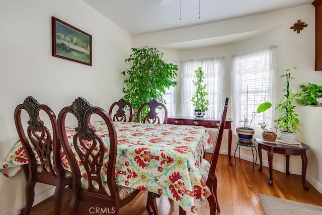dining space featuring light wood-style flooring, baseboards, and ceiling fan
