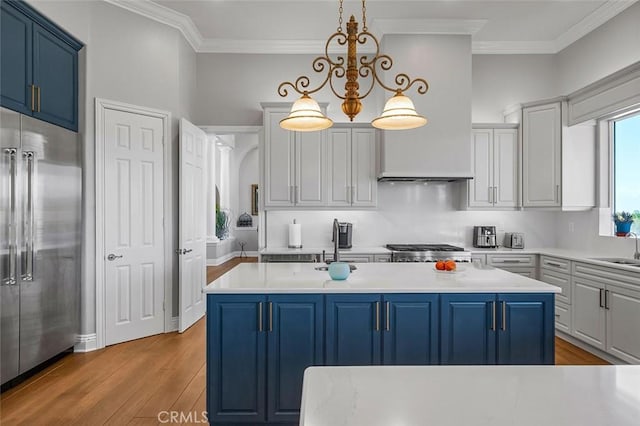 41653 Oak Trail Ct, Murrieta, CA 92562 - kitchen with blue cabinets, high quality fridge, wood finished floors, light countertops, and crown molding